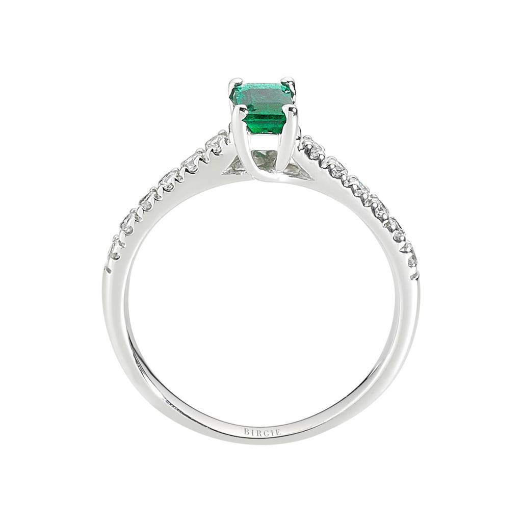 Bague avec centre émeraude et pierres latérales en diamant à griffes fendues