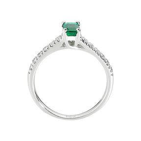 Bague avec centre émeraude et pierres latérales en diamant à griffes fendues