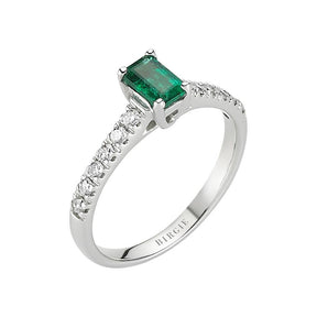 Bague avec centre émeraude et pierres latérales en diamant à griffes fendues